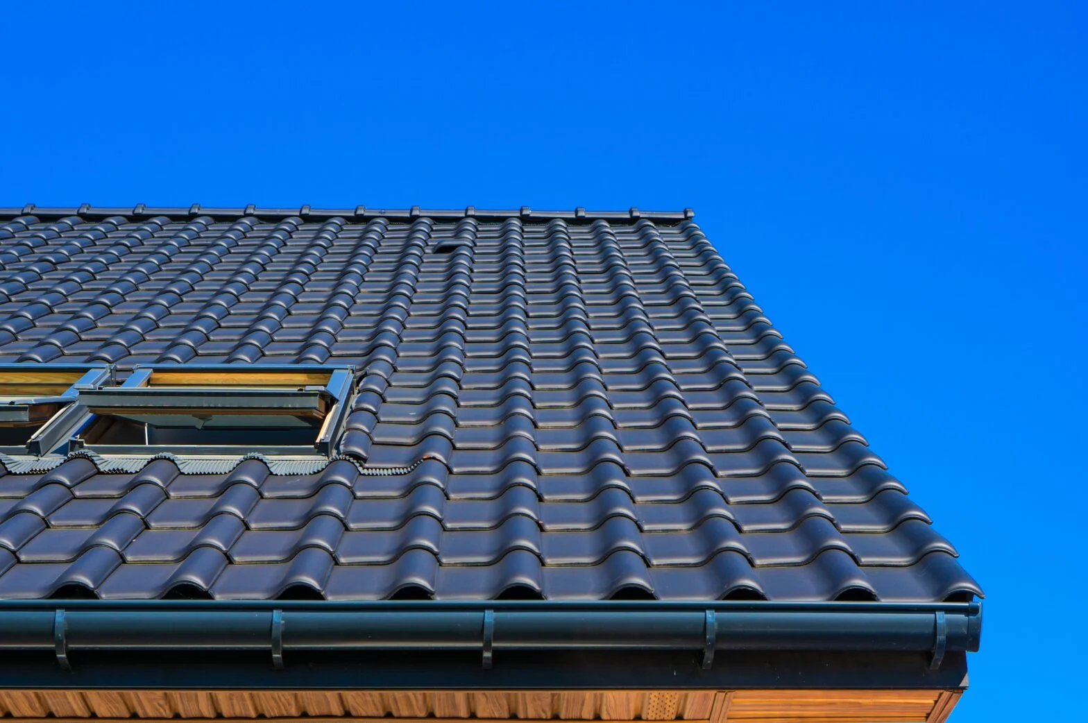 Low-angle architectural view of a rooftop against a clear blue sky