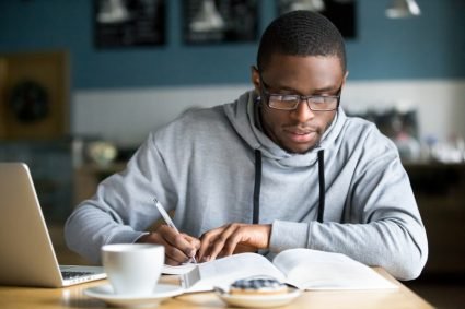 Student focused on studying with a laptop and notes